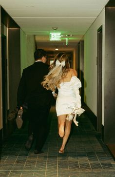 a man and woman walking down a hallway