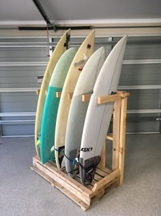 three surfboards are sitting on a rack in a garage