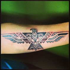 a tattoo on the arm of a man with an eagle and geometric pattern in it