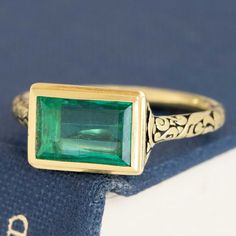 This antique-inspired emerald bezel ring is a bold beauty, bringing tons of color and charm to your ring collection. The chunky gold bezel hugs that Colombian emerald and emphasizes her geometric edges - the darkened engraved shoulders give a Renaissance vibe which we're also quite fond of. The stone sits in the East/West orientation, allowing for maximum spread across the top of the finger. 18kt yellow gold Size 6.25 & resizable Measures: 9.05 x 6.08 x 2.86mm GIA Report Here Please see qualitat Yellow Gold Emerald Signet Ring With Bezel Setting, Rectangular Gold Emerald Ring With Bezel Setting, Art Deco Emerald Ring With Bezel Setting, Art Deco Emerald Jewelry With Bezel Setting, Art Deco Green Jewelry With Bezel Setting, Green Art Deco Jewelry With Bezel Setting, Art Deco Emerald Cut Ring With Bezel Setting, Gold Emerald Ring In Art Deco Style, Gold Emerald Cut Art Deco Ring