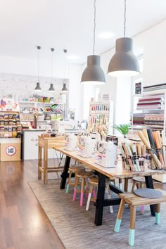 the inside of a craft shop with wooden tables and chairs