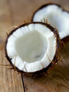 two halves of coconuts on a wooden table