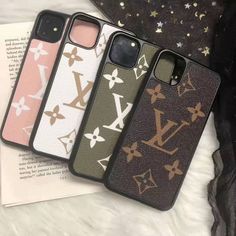 three louis vuitton phone cases sitting next to each other on top of a book