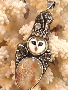 Explore the unknown and magic of life with this little friend.  A dewy eyed little sweetheart of an owl.... This one is wearing a fossil coral coat with a white cubic zirconia in his crown and water cast accents.  Vitreous enamel is finely ground glass that is fused to copper. The painting is created by using a fine paint brush to pick up grains of glass and place them onto the scene. The glass gets fired and melted to fuse it together. It takes 15-20 firings to complete the image.  CZ Vitreous enamel  Fossil Coral  Fine and sterling silver  Silver 24 inch chain  Made in the Spruce Mountain Studio at 9,300ft, by Juliann Follow me on Instagram at SpruceMountain_Studio Free shipping Silver Enamel Oval Pendant Necklaces, Silver Enamel Oval Pendant Jewelry, Sterling Silver Nature-inspired Cabochon Necklace, Barn Owl Necklace, Owl Pendant Gold, Vitreous Enamel, Owl Necklace Silver, Fossil Coral, Owl Necklace