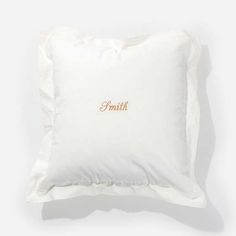 a white pillow with an embroidered name on it