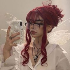 a woman with red hair and glasses taking a selfie