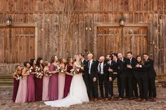 a group of people standing next to each other in front of a wooden building with doors