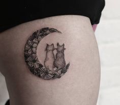 a woman's thigh with a cat and dog tattoo on it