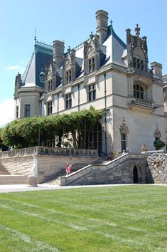 a large building with many windows and lots of grass in front of it on a sunny day