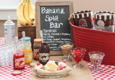 an assortment of desserts and drinks on a table with a sign in the background