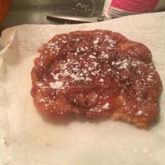 a piece of food sitting on top of a white paper towel next to a knife