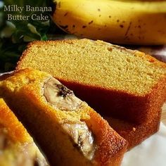 sliced loaf of banana bread on a white plate with two bananas in the back ground