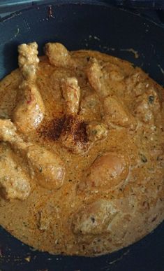 chicken curry in a pan with spices on the top and bottom half, ready to be cooked