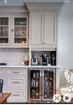 a kitchen with white cabinets and glass doored refrigerator freezer next to a dining room table