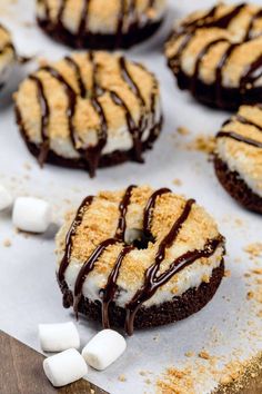 chocolate covered donuts with marshmallows on a baking sheet, ready to be eaten