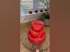 a watermelon cake sitting on top of a glass plate