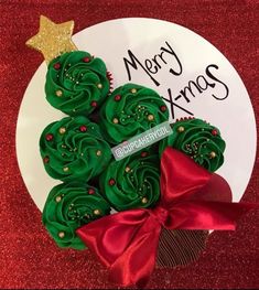 green frosted christmas tree cookies on a plate with red ribbon and gold glitters