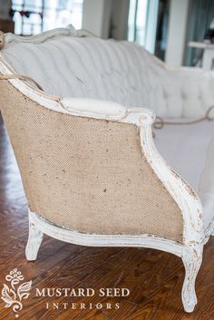 an old white couch sitting on top of a hard wood floor