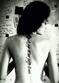 the back of a woman's body with writing on her upper and lower back