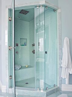 a bathroom with a glass shower and white towels