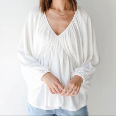 New! “Back In Town” White Blouse, With A V-Neckline, Oversized Babydoll Fit, Long Balloon Sleeves With Elastic Cuffs, And Is Lightweight And Comfortable. Large. Fabric Is 50% Rayon And 50% Poly. Seam To Seam Is 52” Total. Length Is About 27”. Casual Billowy V-neck Tops, Oversized White V-neck Top, Flowy Balloon Sleeve Top For Brunch, Billowy V-neck Top For Daywear, White Billowy Long Sleeve Tops, White Balloon Sleeve Tops With Relaxed Fit, White Billowy Top For Brunch, Relaxed Fit V-neck Tops For Brunch, Casual White Peasant Top With Balloon Sleeves