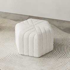 a white ottoman sitting on top of a rug