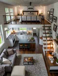 a living room and kitchen with stairs leading up to the loft bed in this modern home