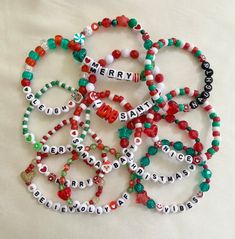 several bracelets that say merry and have beads with letters on them, all in different colors