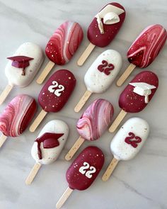 red and white cake pops with graduation decorations on them