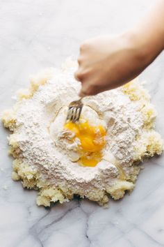 someone mixing ingredients in a bowl with a fork