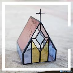 a small stained glass church with a cross on top