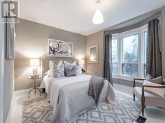 a bedroom with gray walls and white bedding