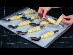 a person cutting up some food on top of a metal tray with utensils