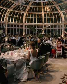 a group of people sitting around a table in a room filled with tables and chairs