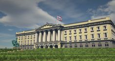 a large building with a flag on top of it's roof and green grass in front