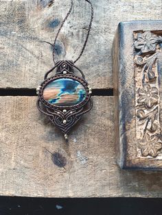 a piece of jewelry sitting on top of a wooden table next to an old book