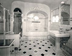 this bathroom has black and white tiles on the floor, walls, and tubs