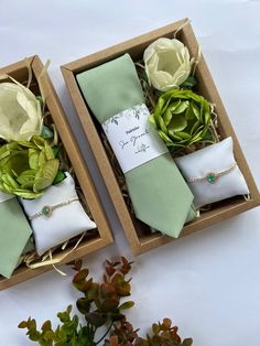 two boxes filled with green and white napkins next to flowers on top of each other