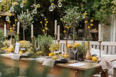 the table is set with lemons and greenery