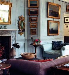 a living room filled with furniture and pictures on the wall above it's fireplace