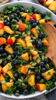 a salad with blueberries, kale and pumpkins