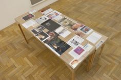 a table with many pictures on it in the middle of a wood floored room