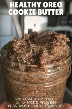 a person holding up a jar filled with cookies