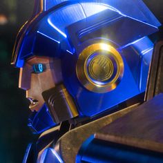 a close up of a person wearing a blue helmet and holding a metal object in his hand