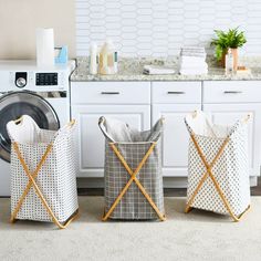 two laundry baskets sitting next to each other in front of a washer and dryer