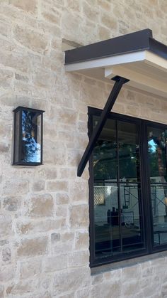 an outside view of a building with two windows and a black awning over the window