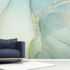 a blue couch sitting in front of a wall with a painting on it's side