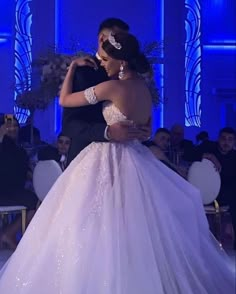 a man and woman are dancing together in front of an audience at a formal event