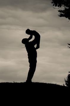 a man standing on top of a grass covered hill