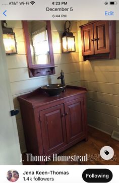 a bathroom with a sink, mirror and lights on the wall next to wood cabinets